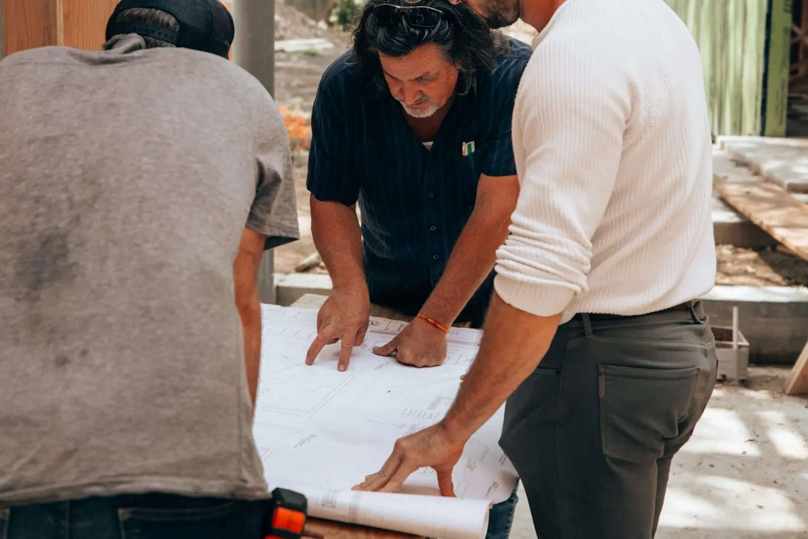 Equipo de ingenieros revisando el avance de obra con planos en mano